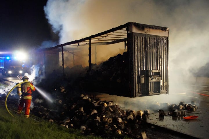Ein Feuerwehrmann löscht den brennenden Lastwagen.