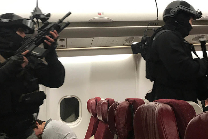 Polizisten einer Spezialeinheit durchkämmen den Flieger nach der Landung.