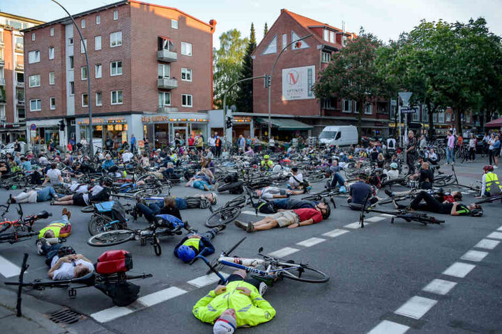Hunderte Radfahrer sitzen oder liegen auf der Kreuzung von Eppendorfer Weg und Osterstraße, um der tödlich verunglückten Radfahrerin zu gedenken.