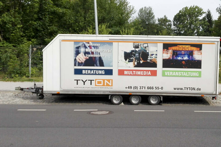 An dem Anhänger befinden sich auffällige Werbeaufdrucke.