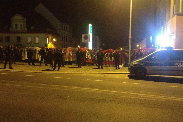 Die Gegendemonstranten zeigen Transparente hoch.