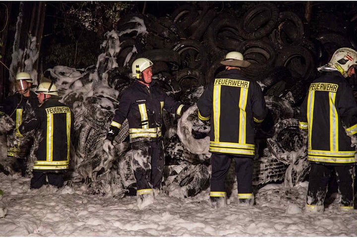 Die Kameraden der Feuerwehr stehen fast knietief im Schaum.