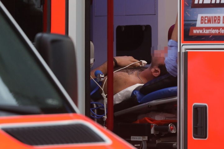 Ein Mann wird von den Sanitätern im Rettungswagen versorgt.