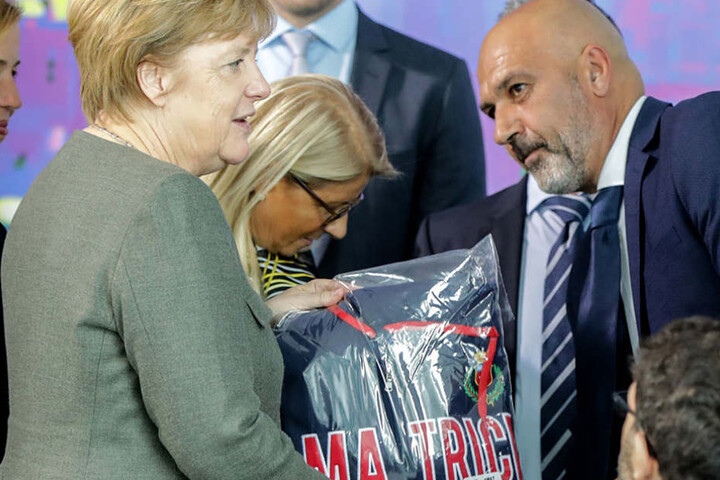 Bundeskanzlerin Angela Merkel erhält von Bürgermeister Sergio Pirozzi einen Kapuzenpulli.