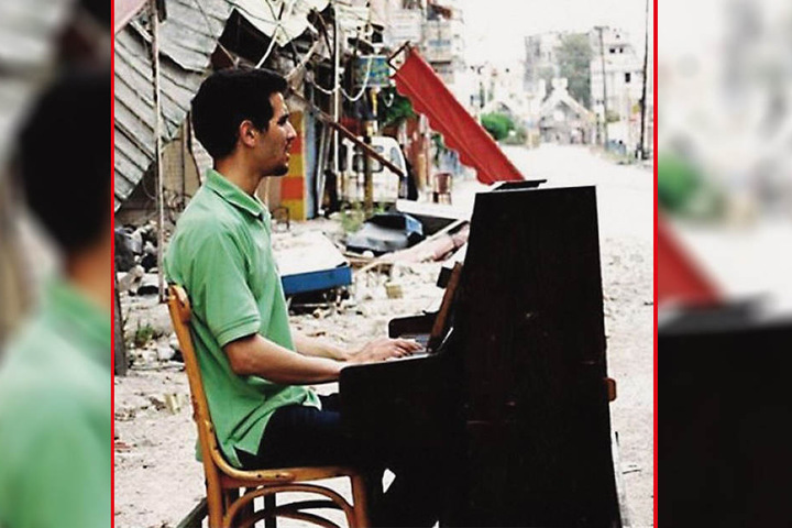 Dieses Bild ging um die Welt: Mitten im syrischen Bürgekrieg sitzt Aeham Ahmad zwischen Ruinen auf der Straße und spielt Klavier. Eingefangen wurde das Bild von Niraz Saied (†27).