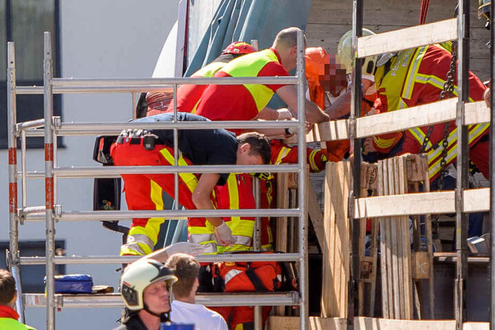 Rettungskräfte befreien den eingeklemmten Bauarbeiter.