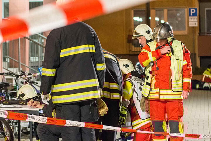 Einsatzkräfte der Feuerwehr werten die im Hausflur genommenen Proben aus.