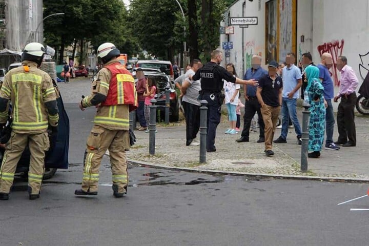 Ein Polizist versucht die Gaffer von der Unfallstelle fernzuhalten.