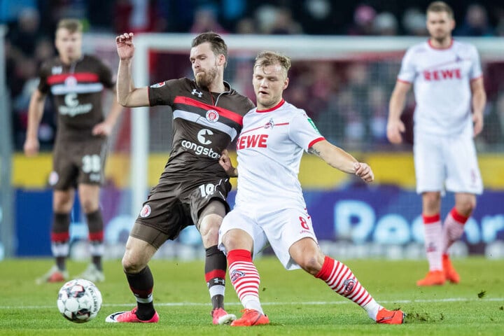 St. Paulis Christopher Buchtmann (l) und Kölns Johannes Geis im Kampf um den Ball.