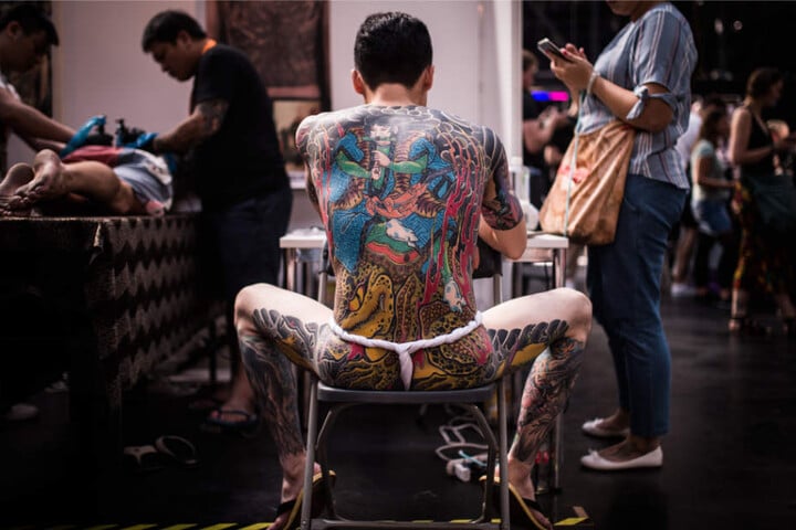 Ein Mann glänzt mit seinem Ganzkörper-Tattoo in der Arena Treptow.