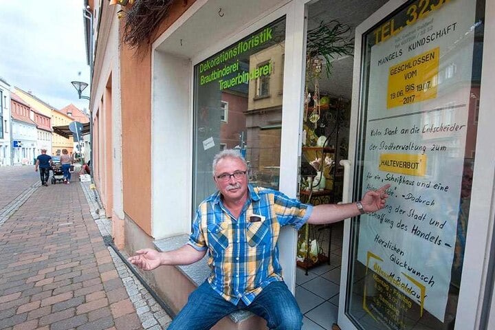Florist Manfred Baldauf (62) macht mit einem riesigen Schild in der Tür des Blumenladens seinem Ärger Luft.