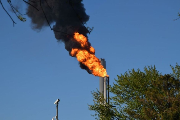 Durch die Aktivität einer Hochfackel bei Shell steigen am Freitagabend schwarze Rauchschwaden auf.