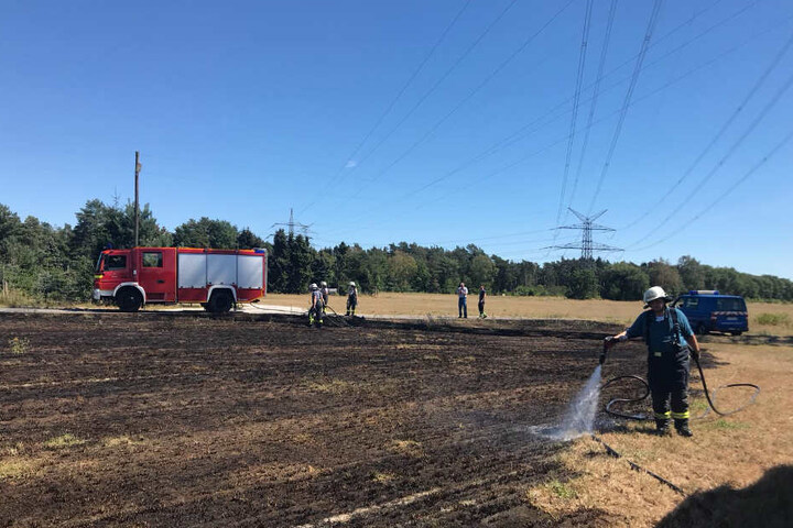 Mehrere Einsatzkräfte wässerten den Boden, um eine Ausbreitung des Brandes zu verhindern.