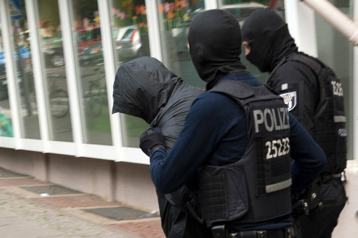 Polizeibeamte führen einen Mann ab. Dreieinhalb Monate nach dem spektakulären Diebstahl einer 100-Kilo-Goldmünze aus dem Berliner Bode-Museum im März 2017 hat die Polizei zwei Verdächtige festgenommen. (Archivbild)
