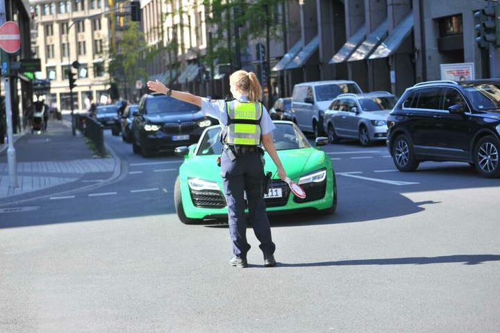 Eine Polizistin winkt einen Audi R8 zur Kontrolle.