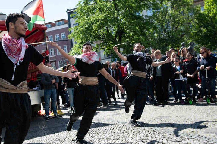 Eine palästinensische Tanzgruppe tanzt auf dem Karl-Marx-Platz in Neukölln, wo sich nach Angaben der Polizei mehr als 100 Menschen zu einer linksradikalen und pro-palästinensischen Demonstration trafen, zu der die Gruppierung "Jugendwiderstand" aufgerufen