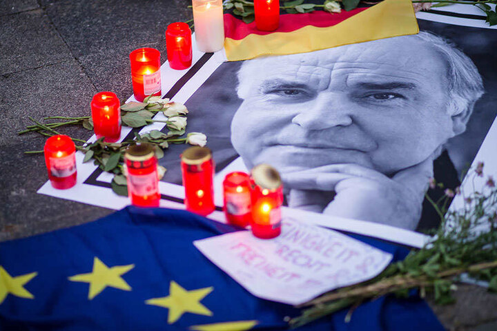 Trauerkerzen stehen in den frühen Morgenstunden am Haus des früheren Bundeskanzlers Helmut Kohl in Ludwigshafen-Oggersheim neben einem Bild von ihm.