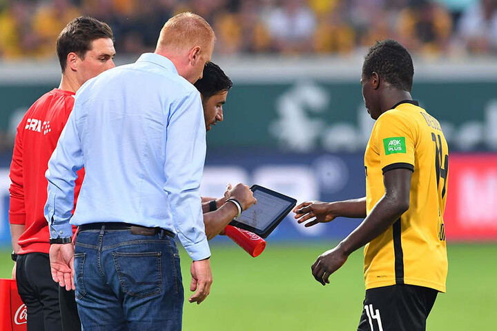 Moussa Koné (r.) bekommt kurz vor seiner Einwechslung von Co-Trainer Ovid Hajou (hint.) per Tablet letzte Hinweise.