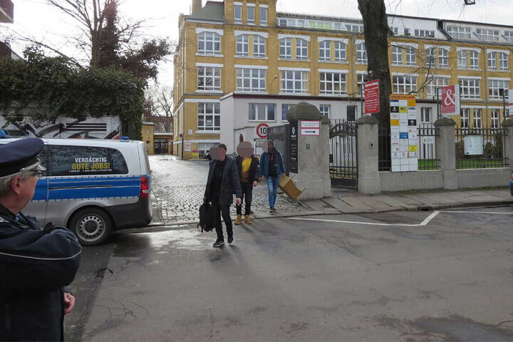 Schüler verlassen unter polizeilicher Aufsicht das Schulgebäude.