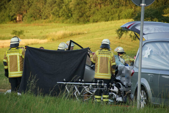 Einsatzkräfte schirmen eines der Wracks während ihrer Arbeit durch einen Sichtschutz ab.
