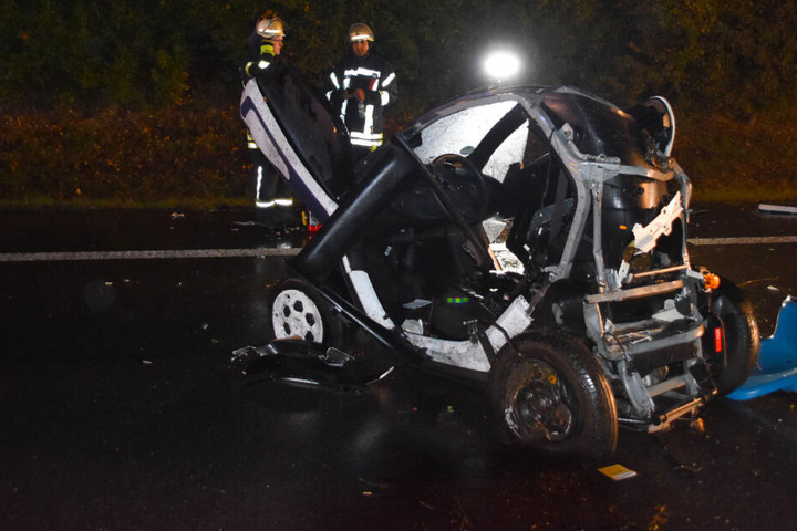 Feuerwehrleute hinter dem verunglückten Elektrofahrzeug.