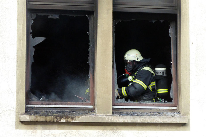 Ein Feuerwehrmann löscht am 14.09.2016 in Nordhausen (Thüringen) einen Brand in einem Mehrfamilienhaus.