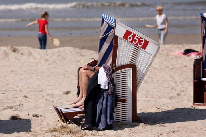 Urlauber sitzen Mitte April in einem Strandkorb auf Norderney.