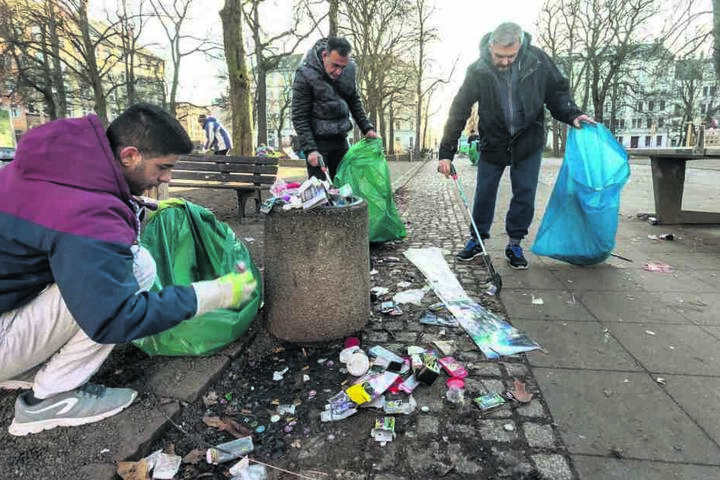 Sadegh (30), Mohamad (50) und Thomas (v.l.) räumten die Feuerwerksreste auf dem Lessingplatz weg.