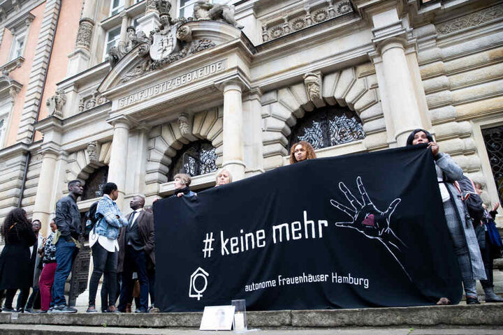 Menschen stehen bei einer Mahnwache für die getötete Frau vor dem Strafjustizgebäude.