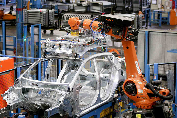 Roboter des Herstellers Kuka bauen im Ford Werk in Köln eine Karosserie zusammen.