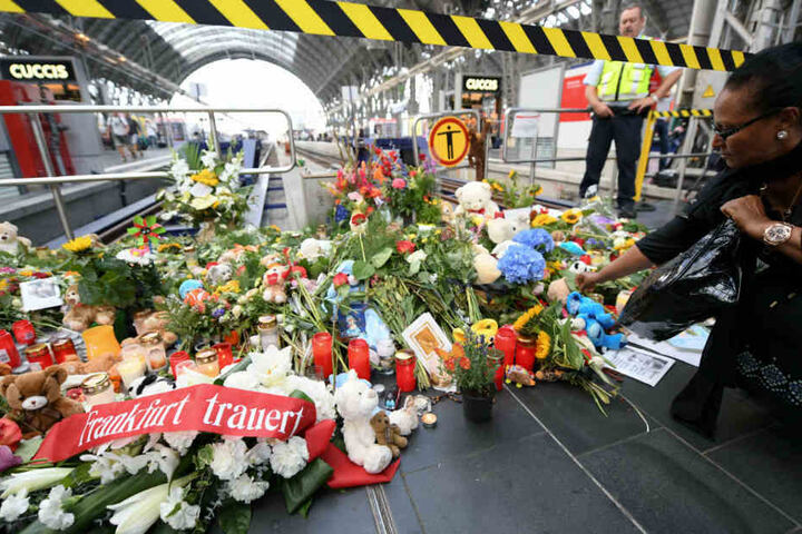 Eine Frau legt am Tatort am Gleis 7 des Hauptbahnhofs Blumen für den getöteten Achtjährigen ab.