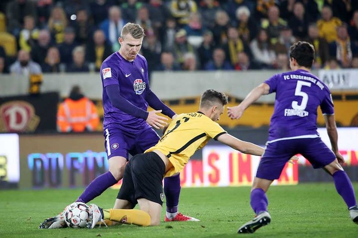 Aues Steve Breitkreuz (li) und Clemens Fandrich (re.) nehmen Dynamos Stürmer Lucas Röser in die Zange.
