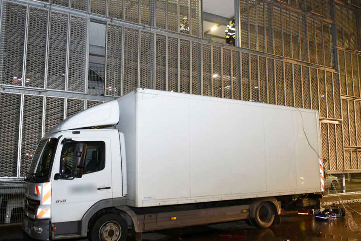 Ein Auto durchbrach die Außenwand eines Parkhauses und flog über einen Lastwagen.