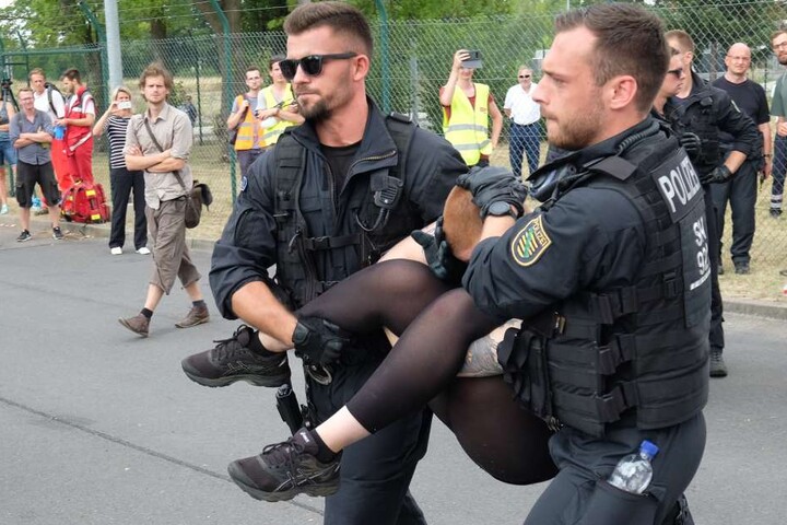 Eine Kohlegegnerin wird von Polizeibeamtin weggetragen.