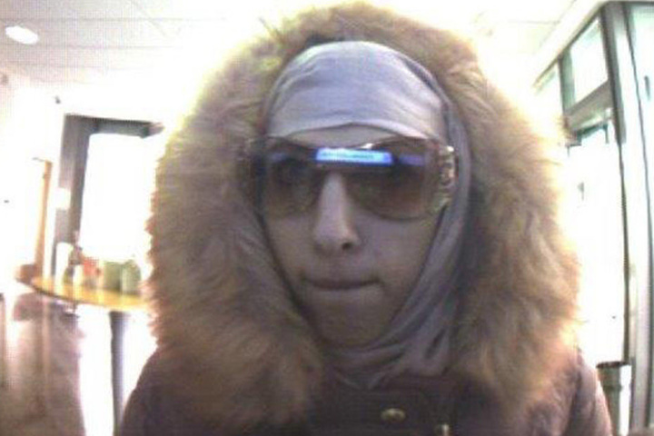Mit Hilfe einer Sonnenbrille, versucht die Verbrecherin ihr Gesicht zu schützen.