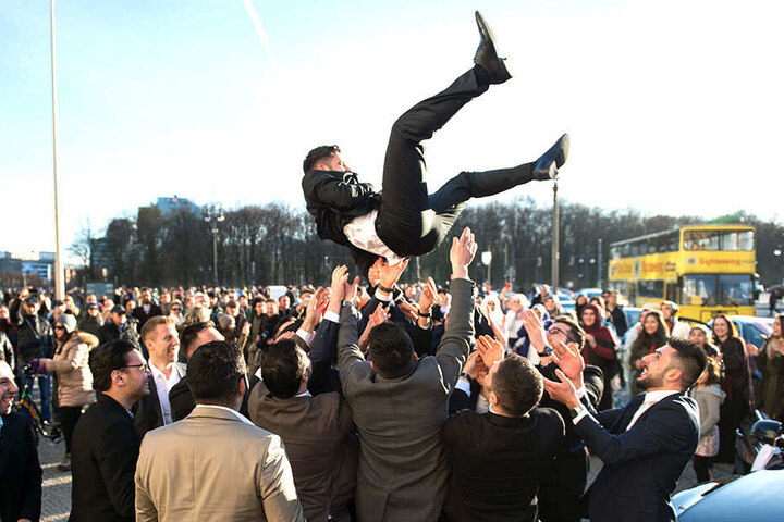 Bei einer türkischen Hochzeitsfeierlichkeit in Berlin werfen Männer den Bräutigam in die Luft (Symbolbild).