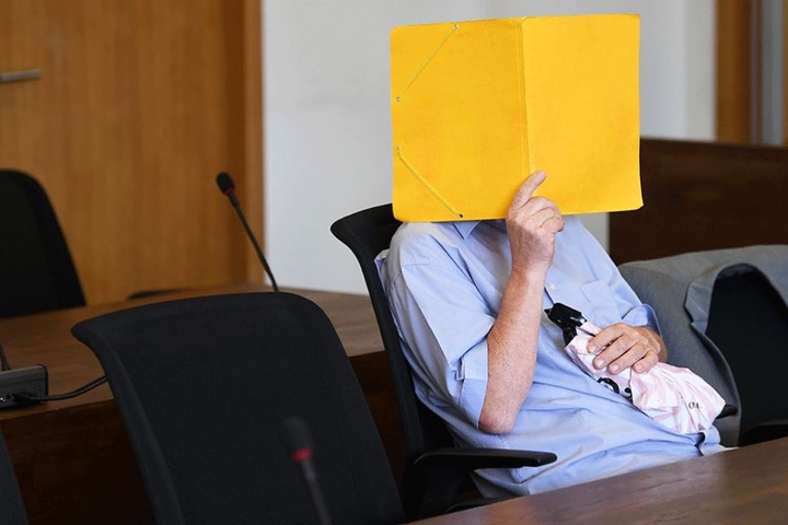 Der Angekläffte verbirgt sein Gesicht zum Prozessauftakt hinter einem Ordner.