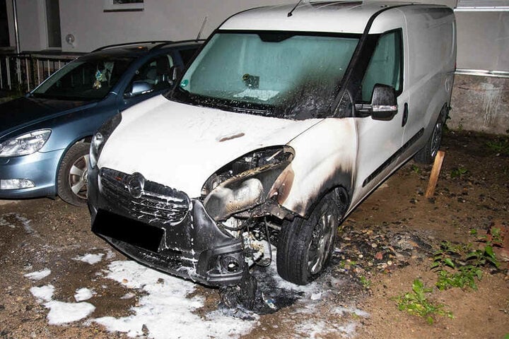Der in Brand geratene Leihwagen, ein weißer Opel Combo ist gelöscht. Der Schaden ist deutlich sichtbar.