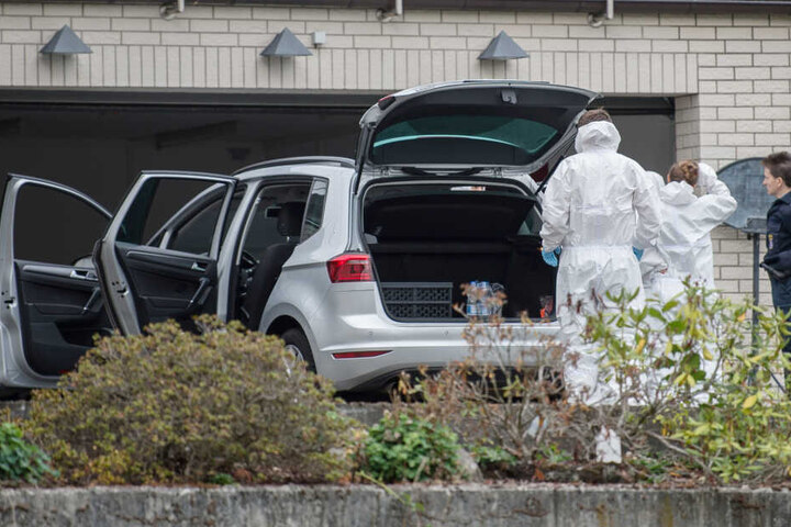 Mitarbeiter der Spurensicherung stehen vor der Garage des Hauses im Mörlenbach.