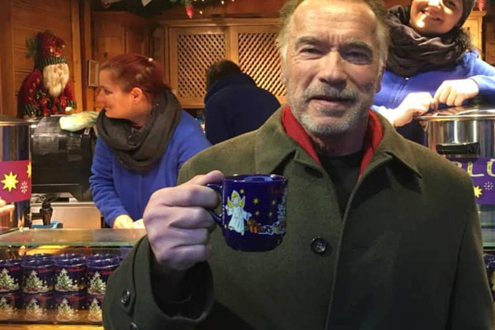 Arnold Schwarzenegger ließ sich auf dem Christkindlmarkt in München vor einem Stand fotografieren.