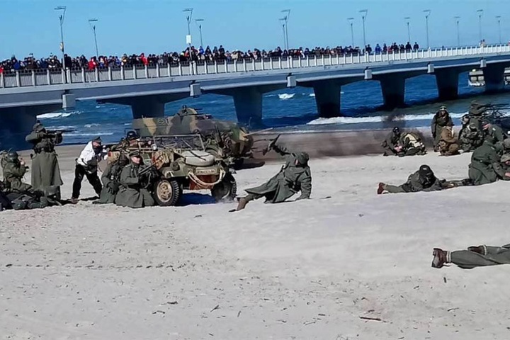 Während im Sand gekämpft wird, drängen sich Schaulustige auf der Seebrücke.