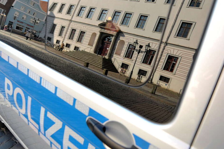 Das Landgericht Lüneburg (Niedersachsen) spiegelt sich in der Scheibe eines Polizeifahrzeuges.