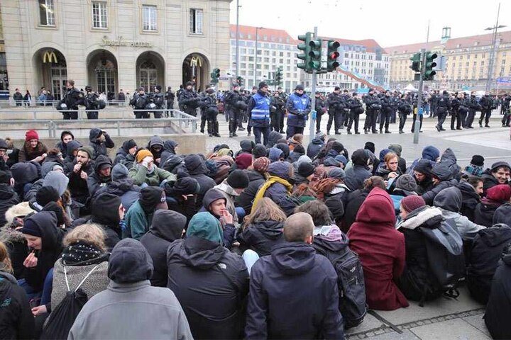 Am Altmarkt hat sich eine Sitzblockade formiert. Die Polizei versucht die Gegendemonstranten dazu zu bewegen, die Strecke frei zu geben.