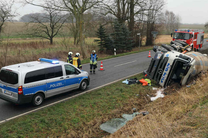 Einsatzkräfte von Polizei und Feuerwehr stehen an der Unfallstelle.