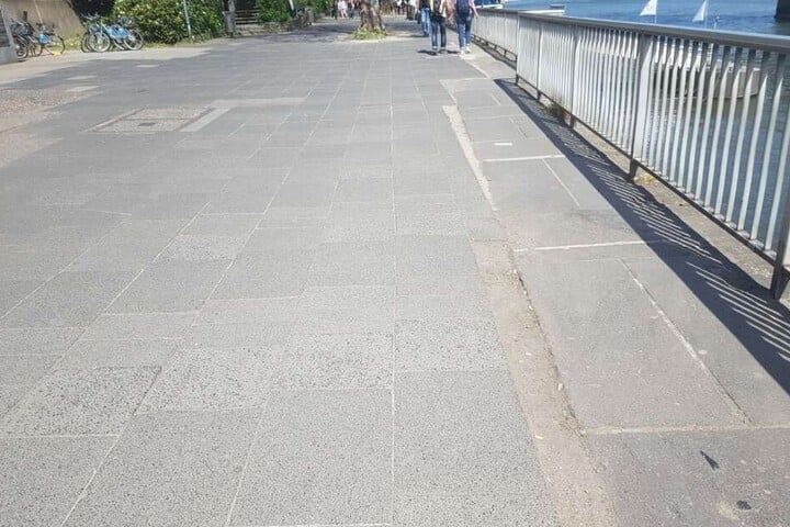 Schräge Verschnitte, graue Platten und teils lose Platten ebnen die "Flaniermeile" am Rhein.