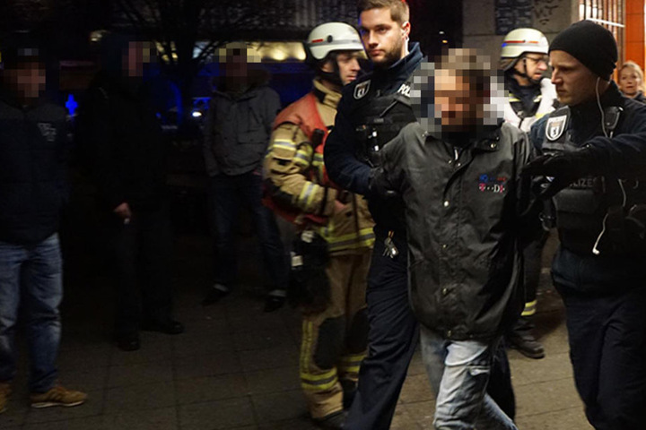 Beamte führen den Mann nach der Rettungsaktion in Handschellen ab.
