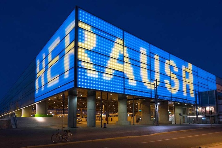 Schriftzug und Fassade wechseln die Farben zwischen Blau und Gelb.