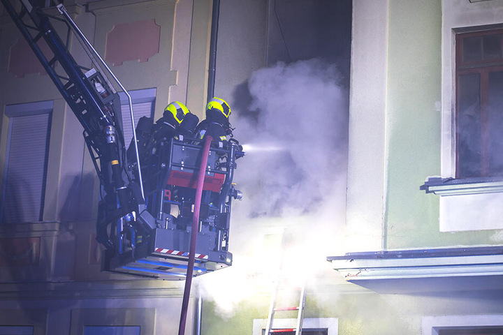 Feuerwehrleute löschen die Flammen. Die Polizei weiß noch nicht, um wen es sich bei dem oder der Toten handelt.