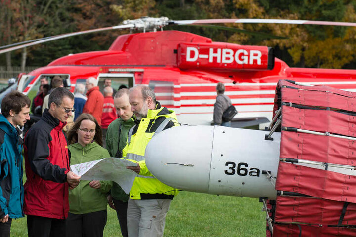Rohstoffexperten überwachen Testflüge der Hubschrauber, die mit Hilfe von Sonden Bodenschätze orten sollen.