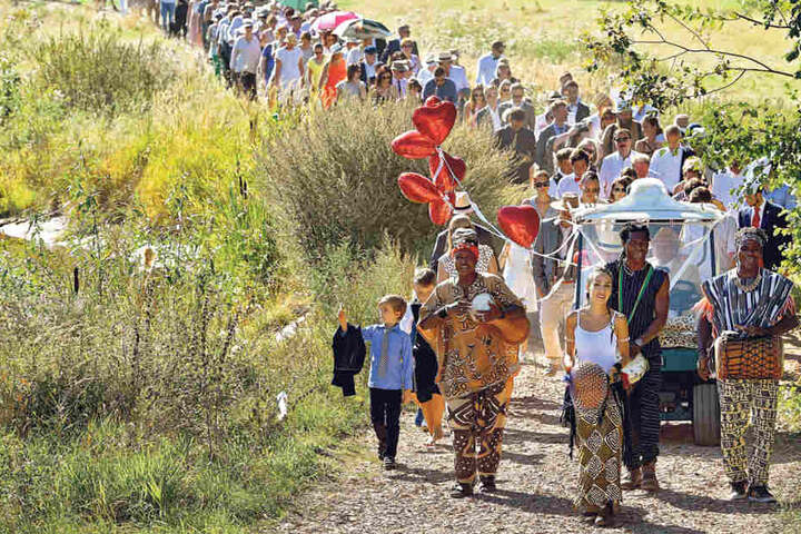 Afrikanische Musiker führen den Hochzeitszug zum Safari-Camp an. Gleich
hinter ihnen fährt das vermählte Paar im Golfwagen.